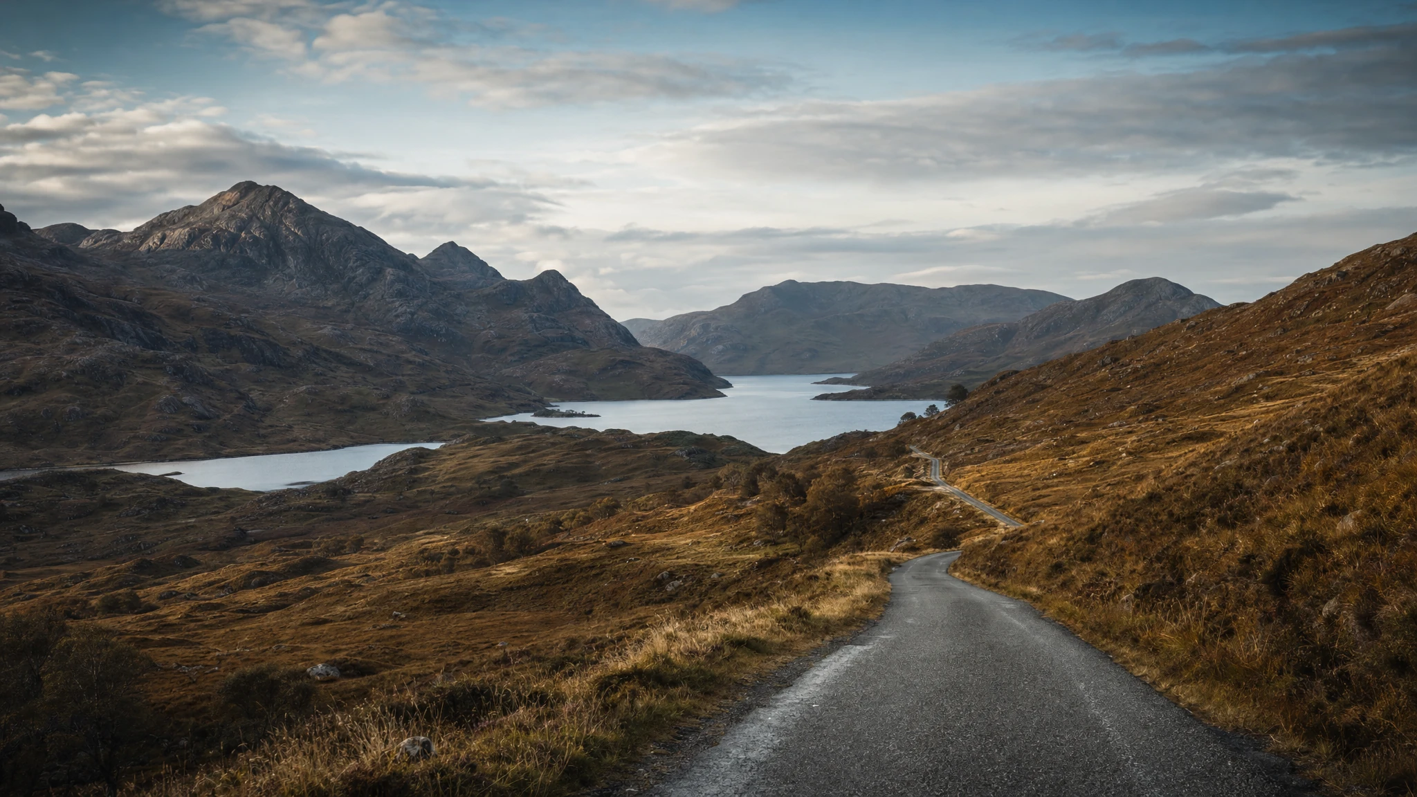 An open road sweeping north into the Scottish Highlands
